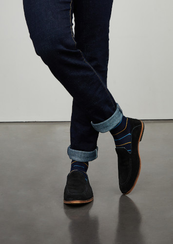 Les pieds d'un homme dans une posture élégante portant des chaussettes rayées